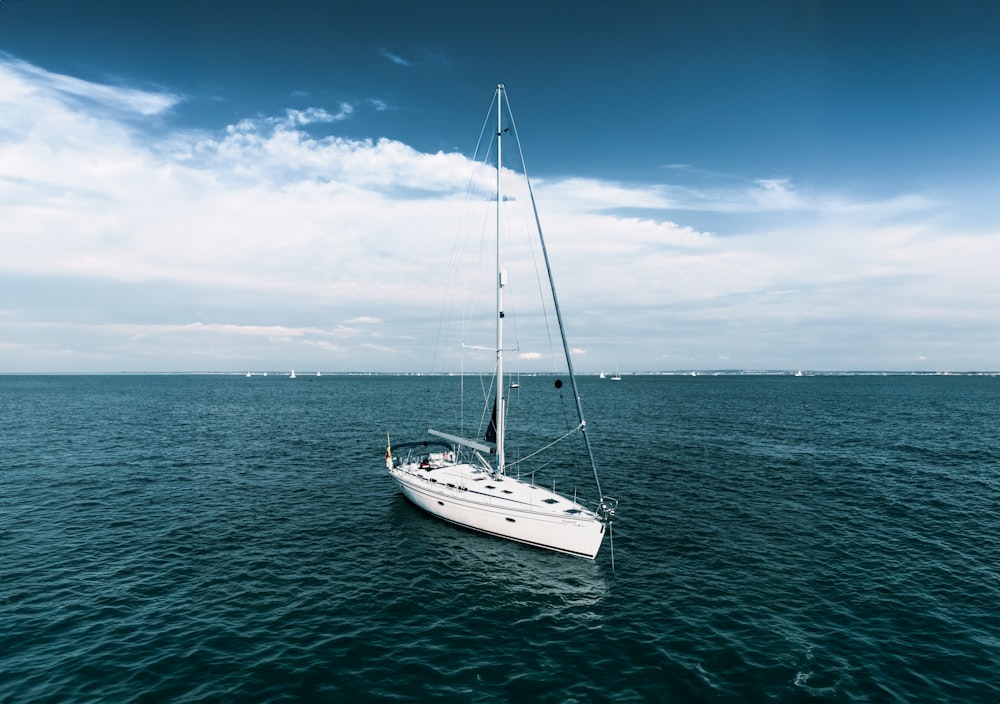 a white sailboat floating on top of a large body of water