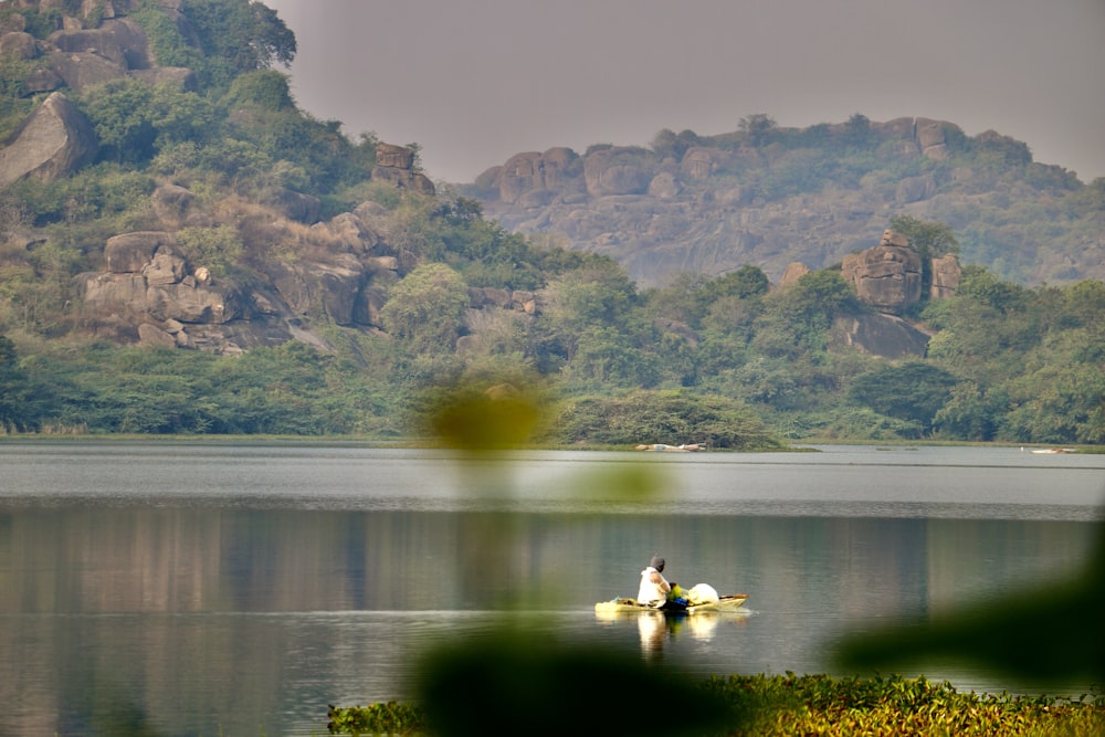 a person in a small boat on a lake