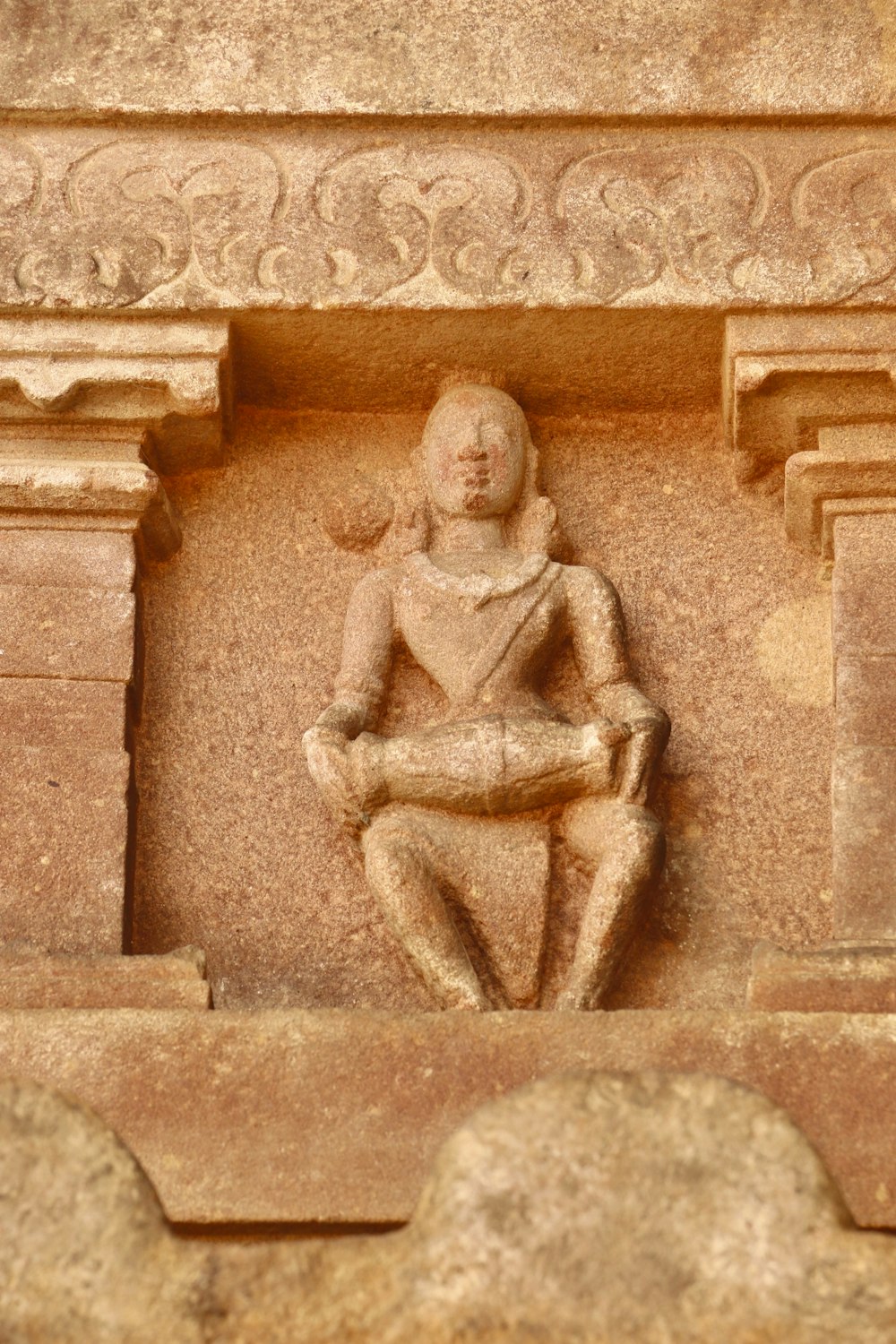 a statue of a man sitting on a ledge
