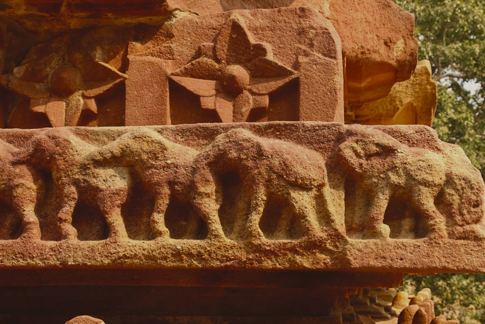 a close up of a stone carving of elephants