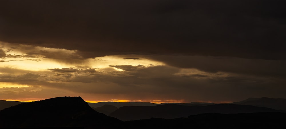 the sun is setting over a mountain range