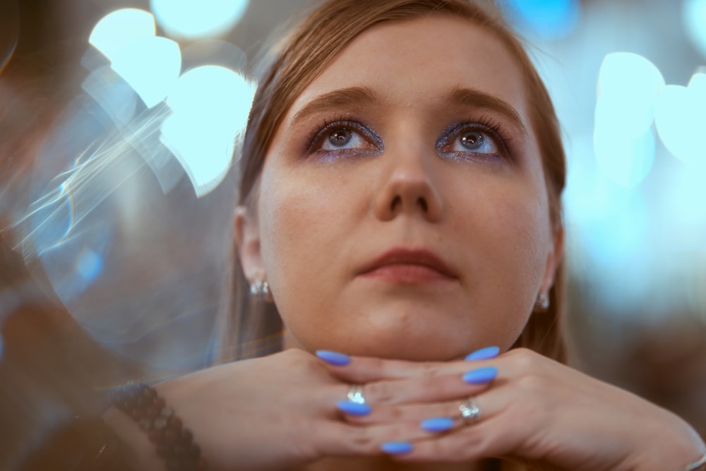 a woman with blue nails and a ring on her finger