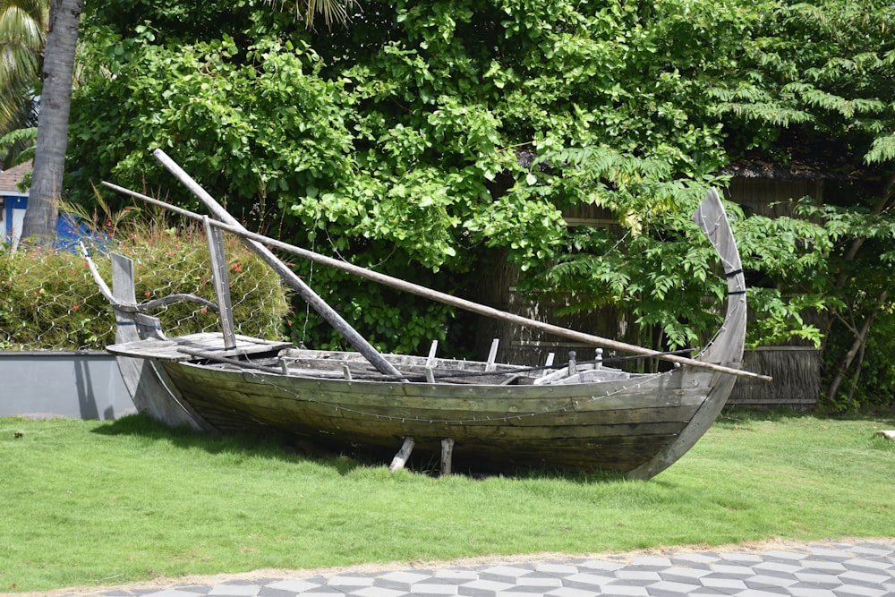 a boat sitting on top of a lush green field