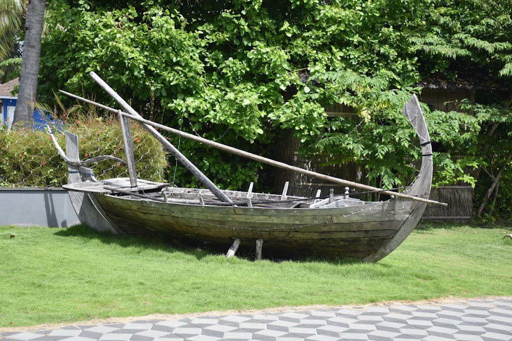 a boat sitting on top of a lush green field
