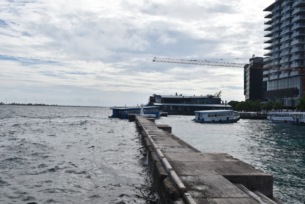 a dock with boats and a crane in the background