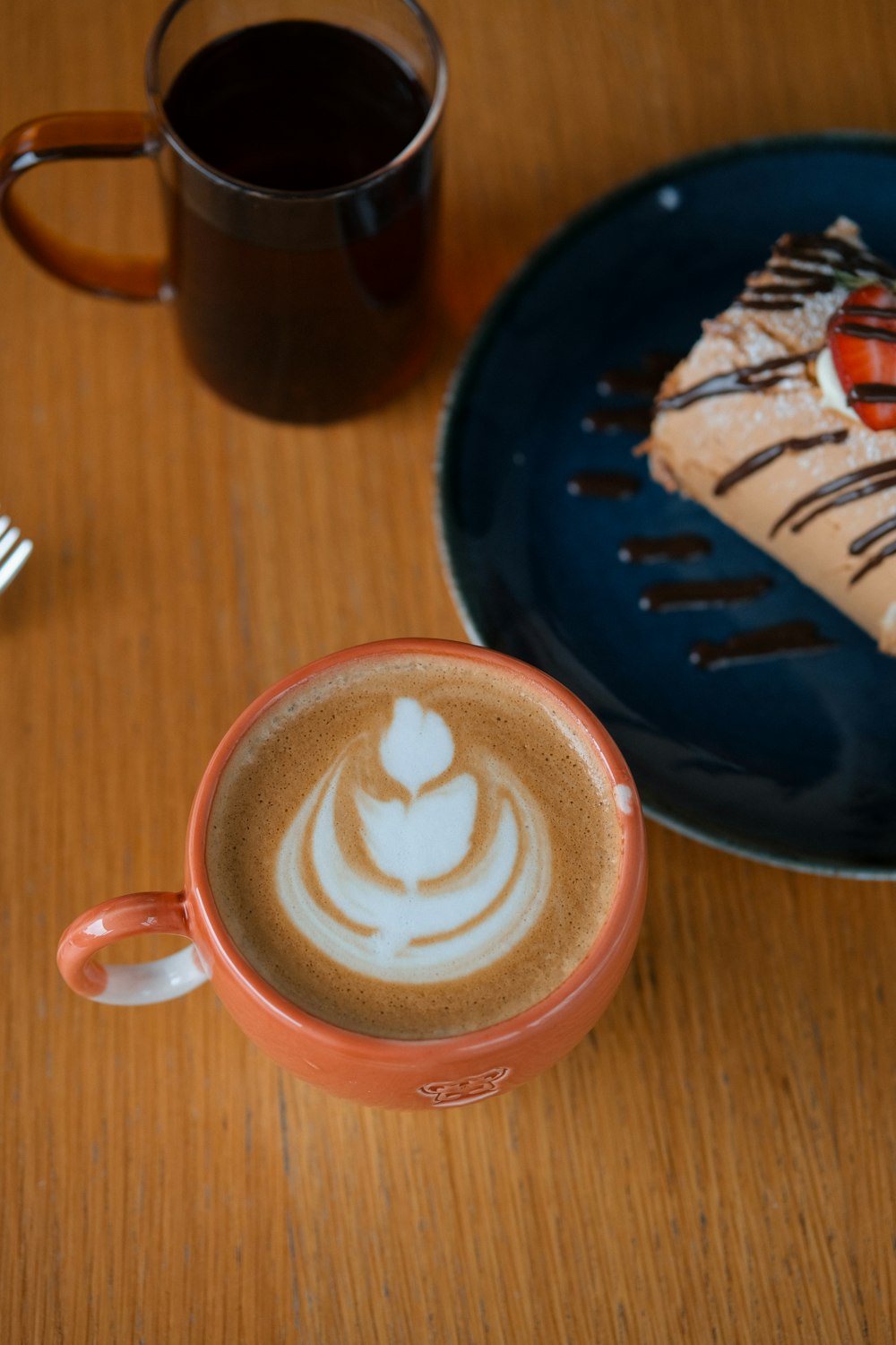 a cup of coffee sitting on top of a wooden table