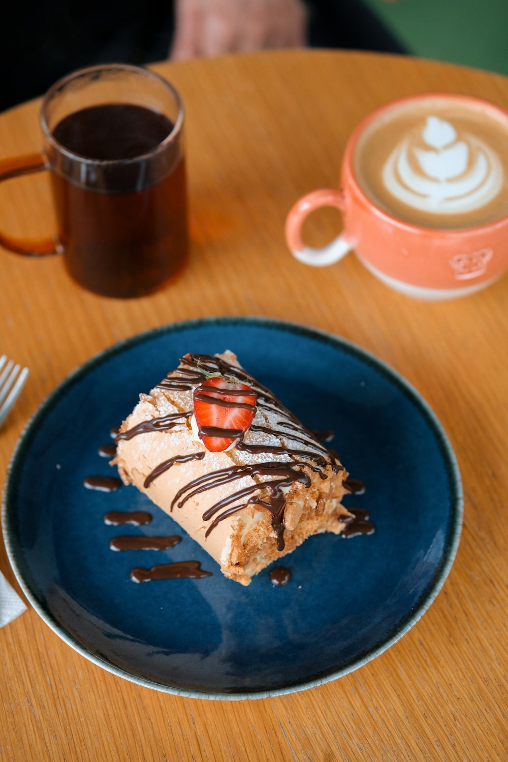 a piece of cake sitting on a blue plate next to a cup of coffee