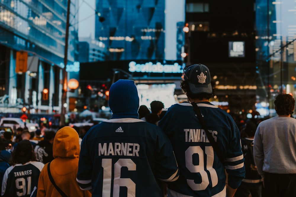 two hockey players are walking down the street