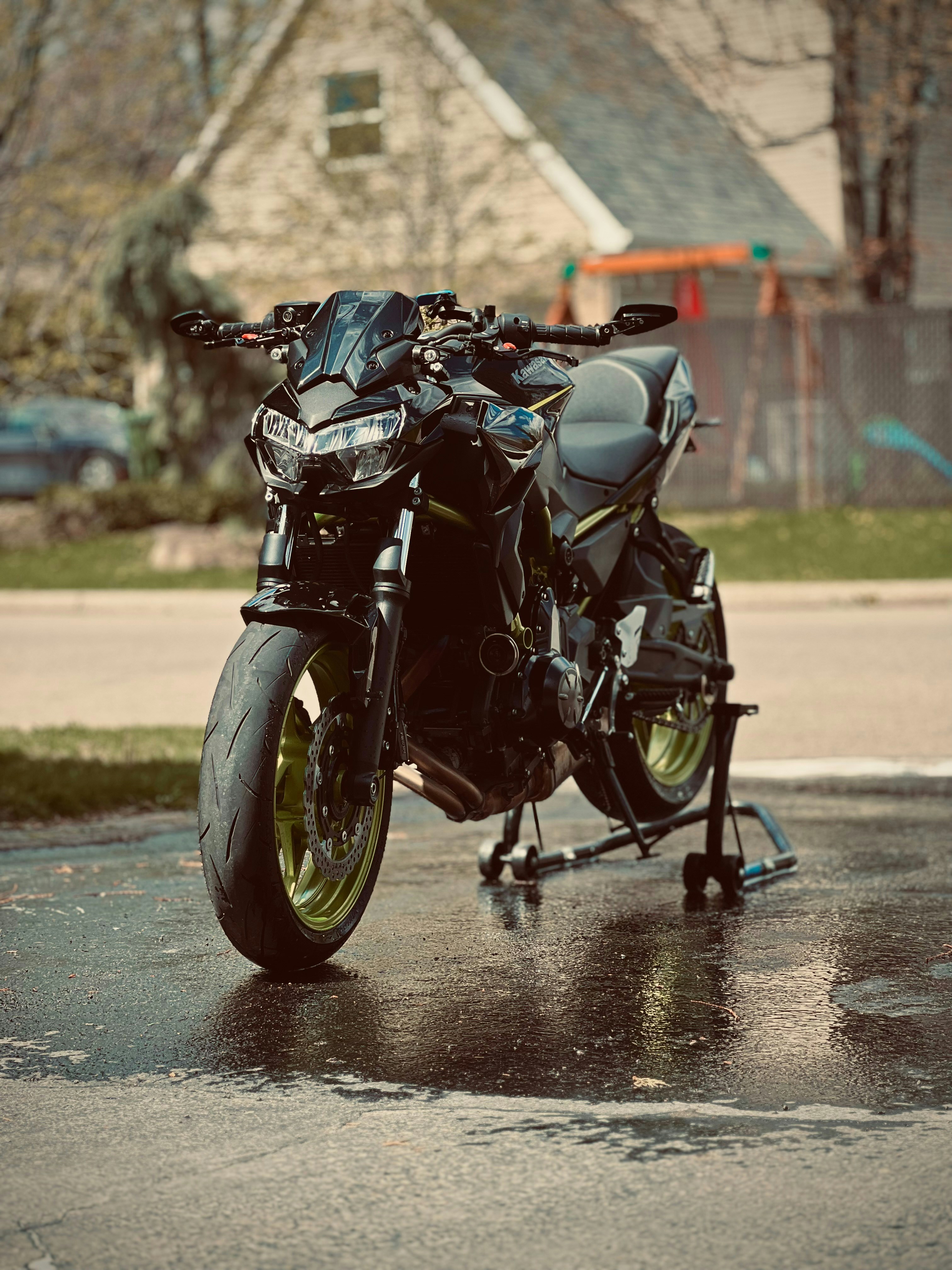 a black motorcycle parked on a wet street