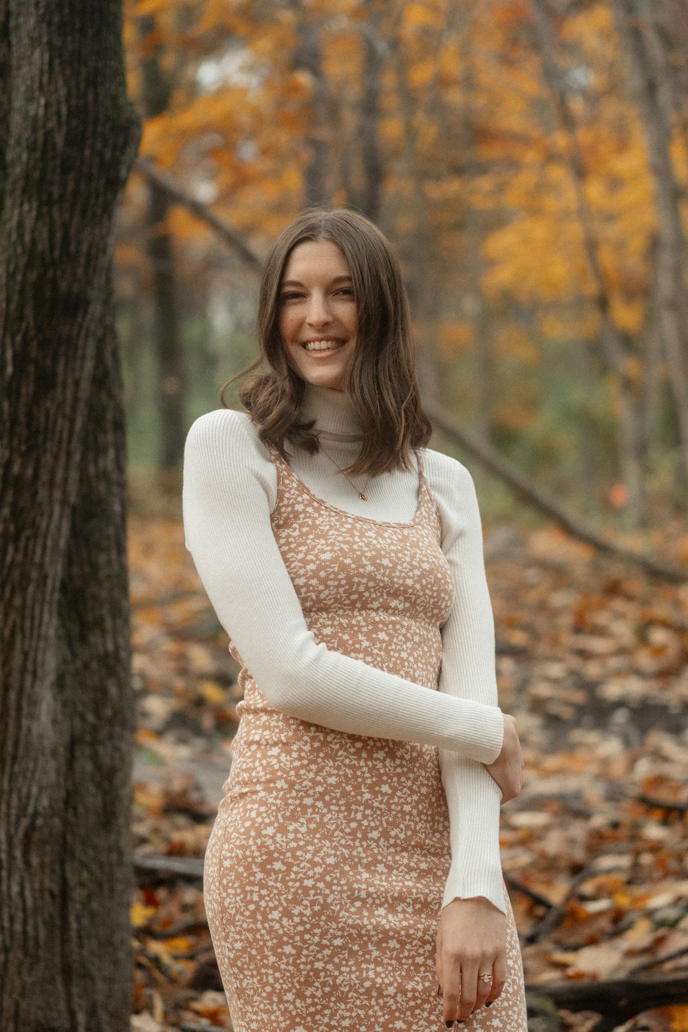 a woman in a dress standing in the woods