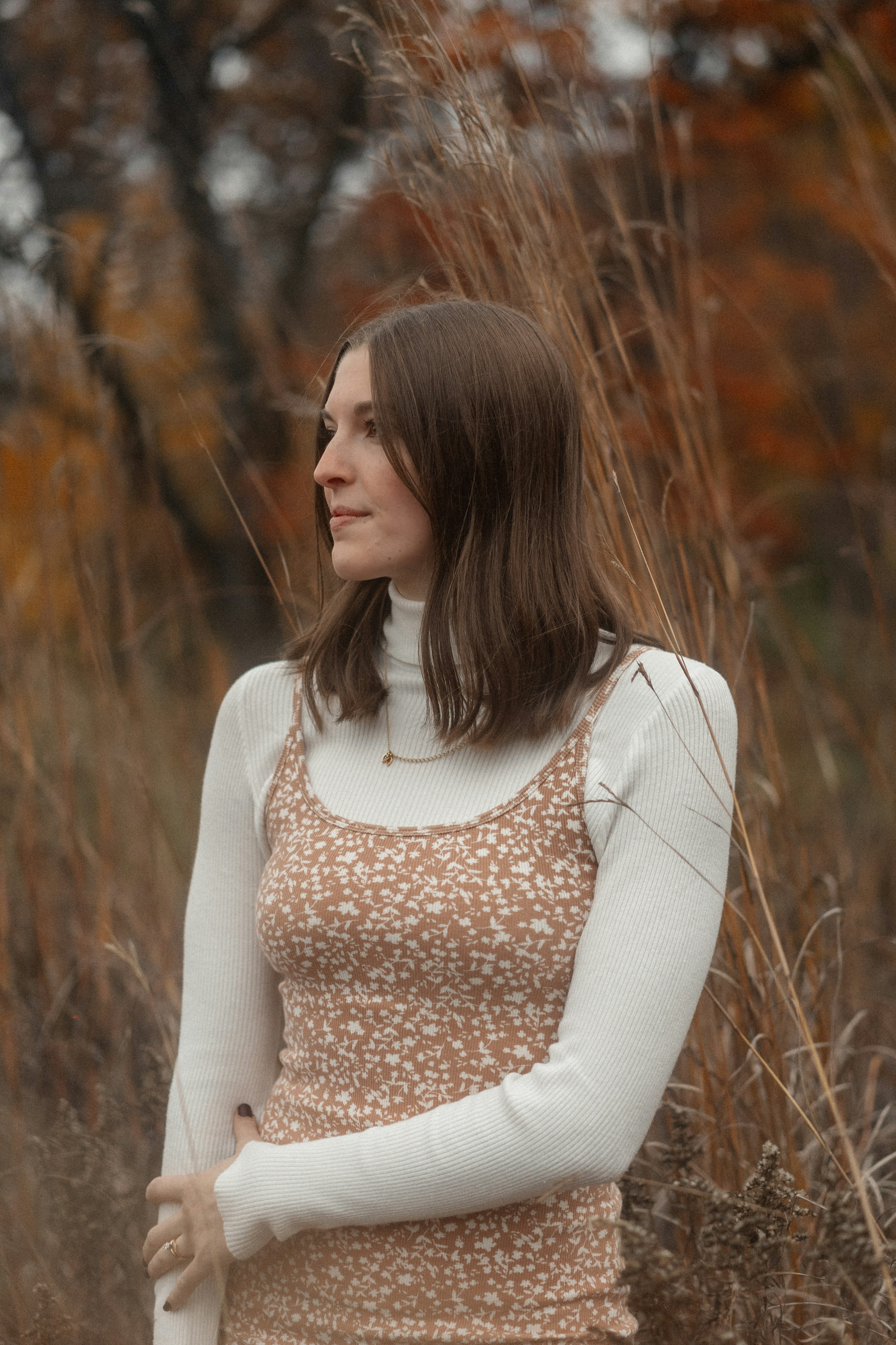 a woman standing in a field of tall grass