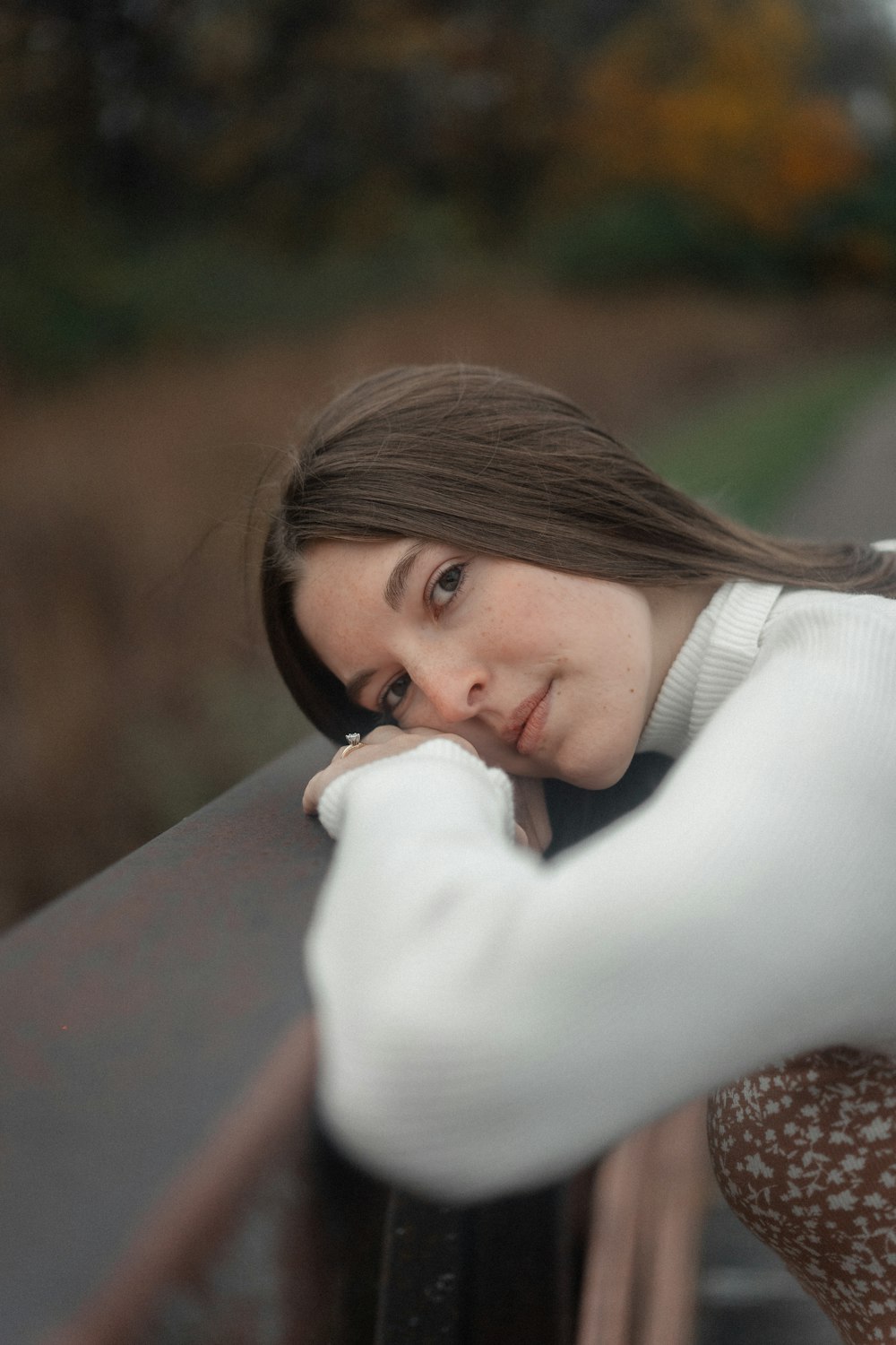 a woman leaning on a rail with her hand on her face