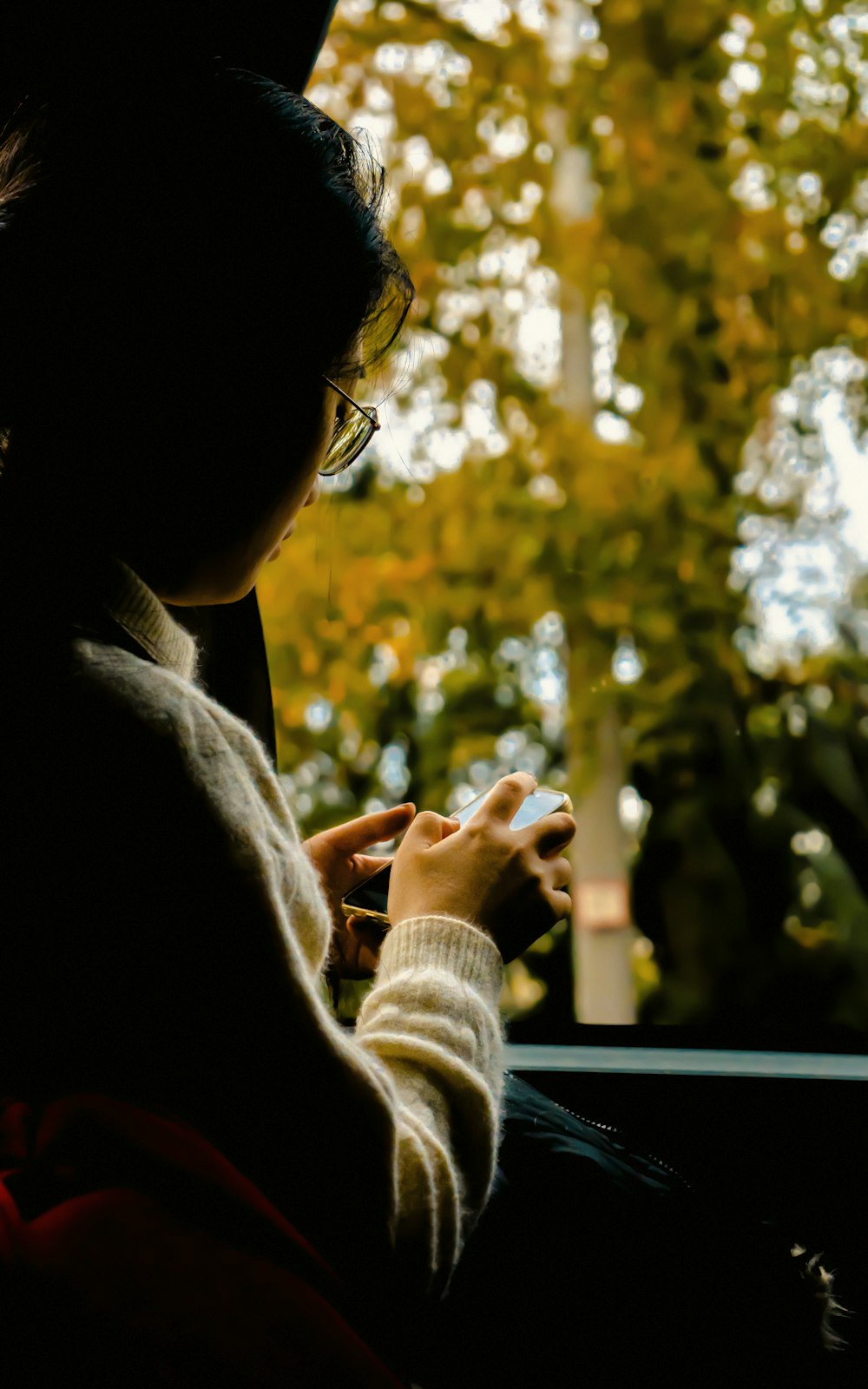 a woman sitting in a car looking at her cell phone