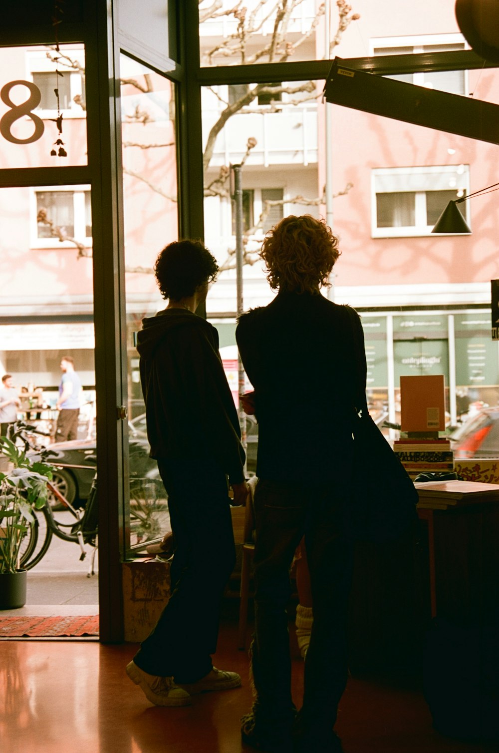 a couple of people standing in front of a window