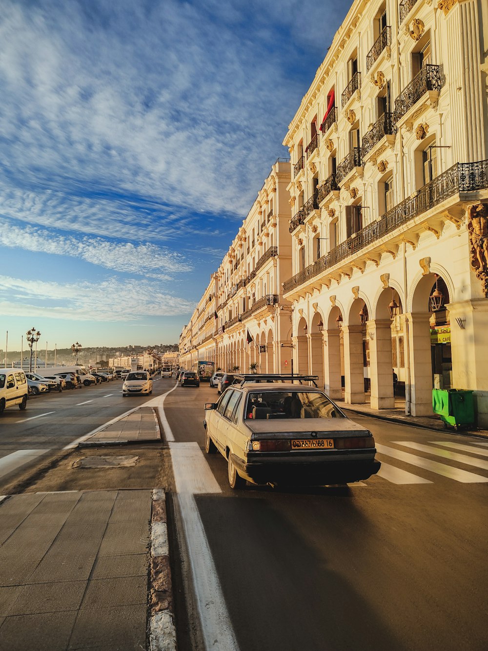 a car driving down a street next to a tall building