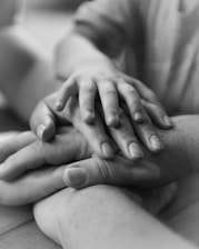 a couple of people holding hands on top of each other