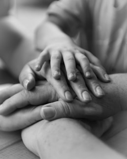 a couple of people holding hands on top of each other