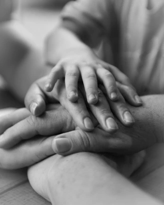 a couple of people holding hands on top of each other
