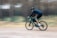 a man riding a bike down a dirt road