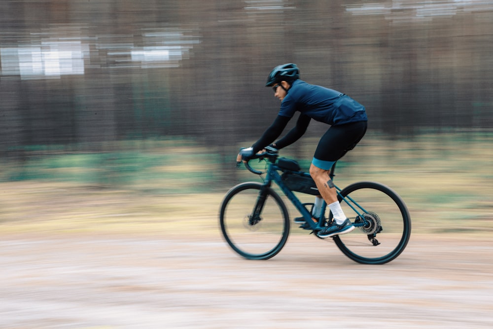 a man riding a bike down a dirt road