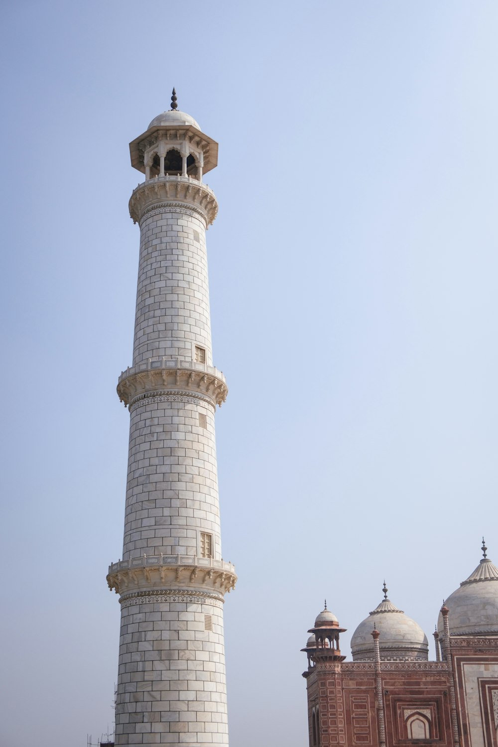 ein hoher weißer Turm mit einer Uhr auf der Spitze