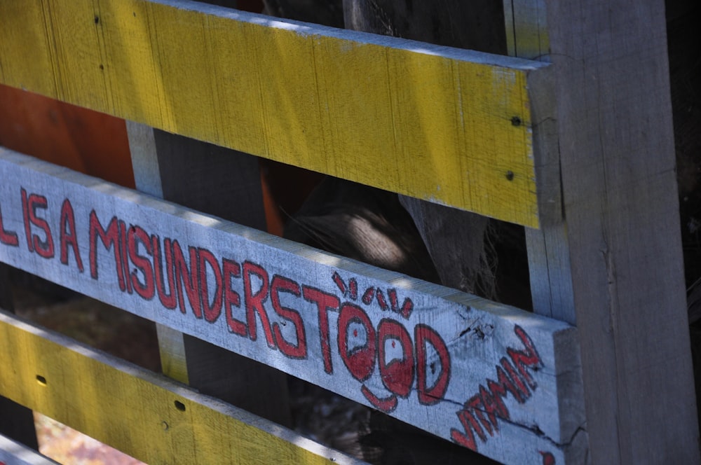 a close up of a wooden fence with graffiti on it