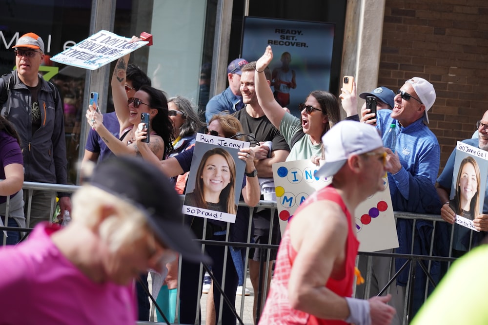 a group of people holding up signs in front of a fence