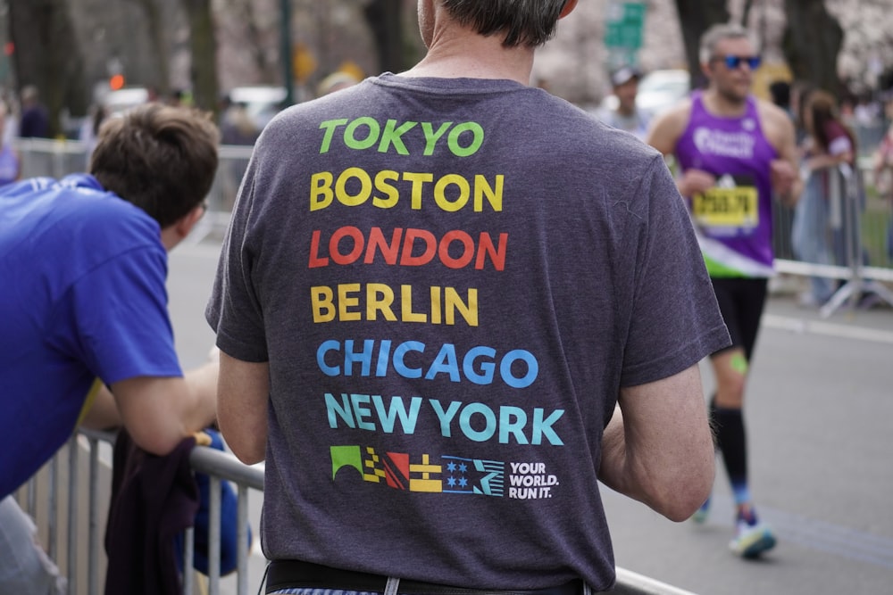 Un hombre con una camiseta que dice Tokio, Boston, Londres, Berlín, Chicago, Nueva York