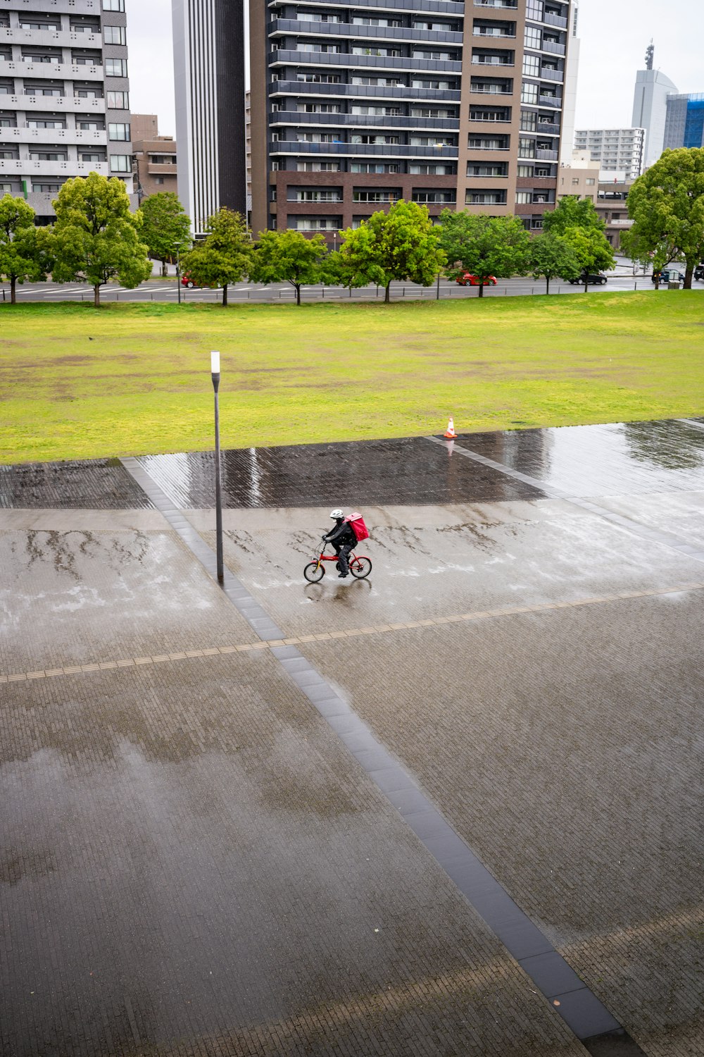 a man riding a bike down a rain soaked street