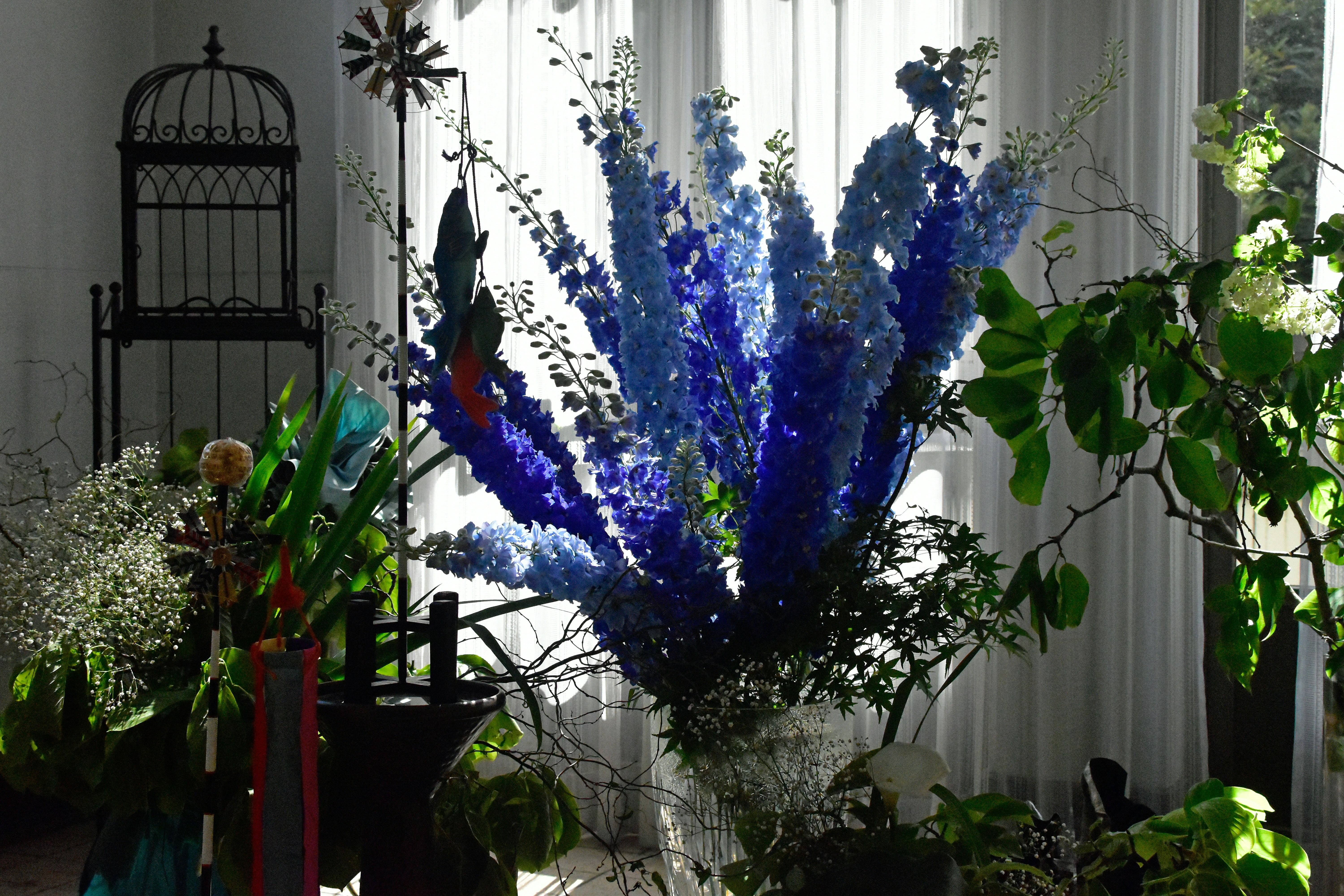 a vase filled with blue flowers next to a window