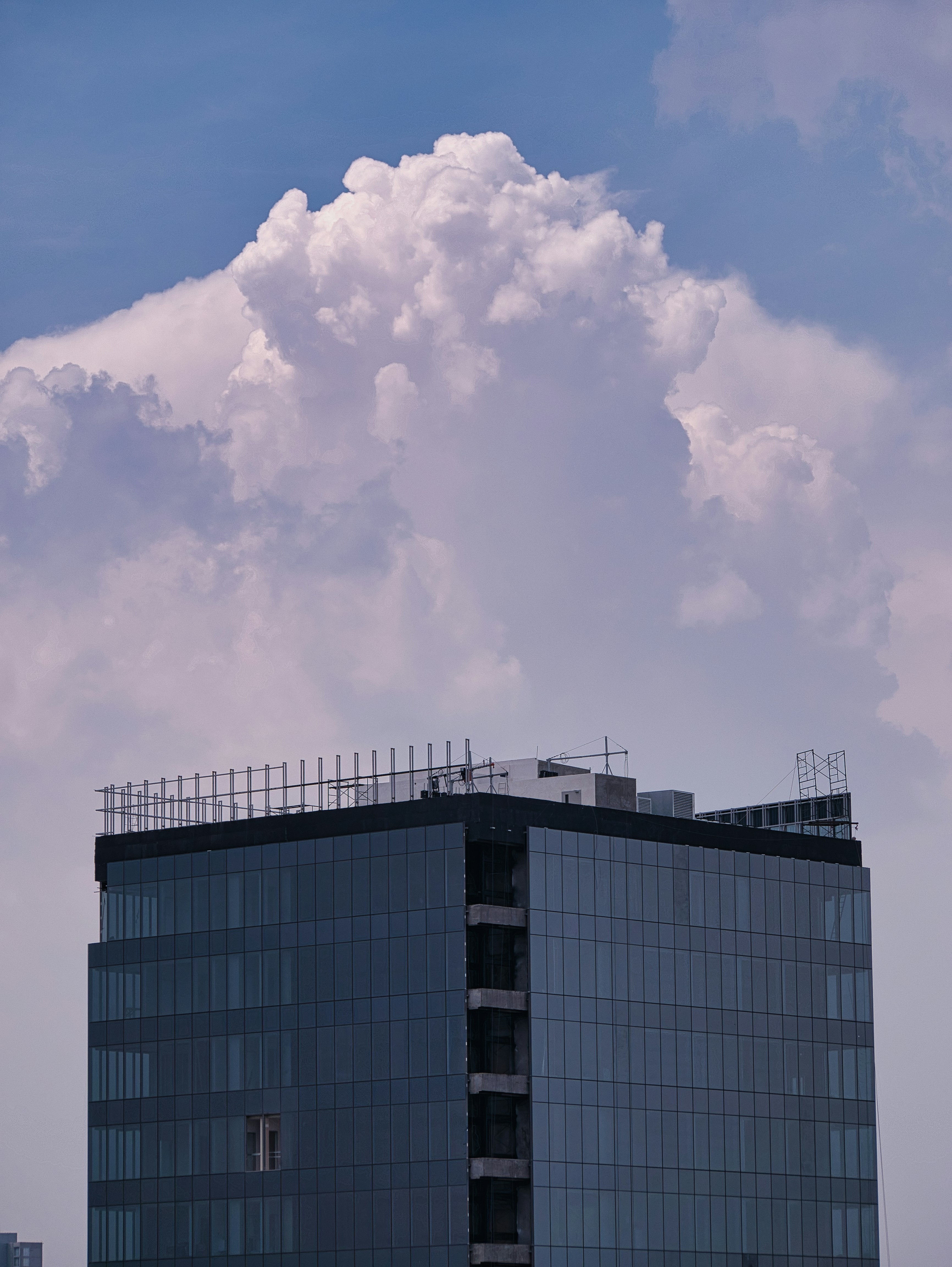 a very tall building with a very big cloud in the sky