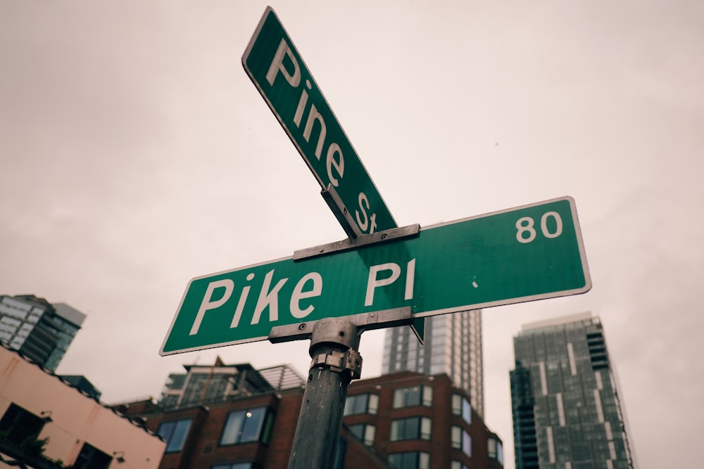 a green street sign sitting on top of a metal pole