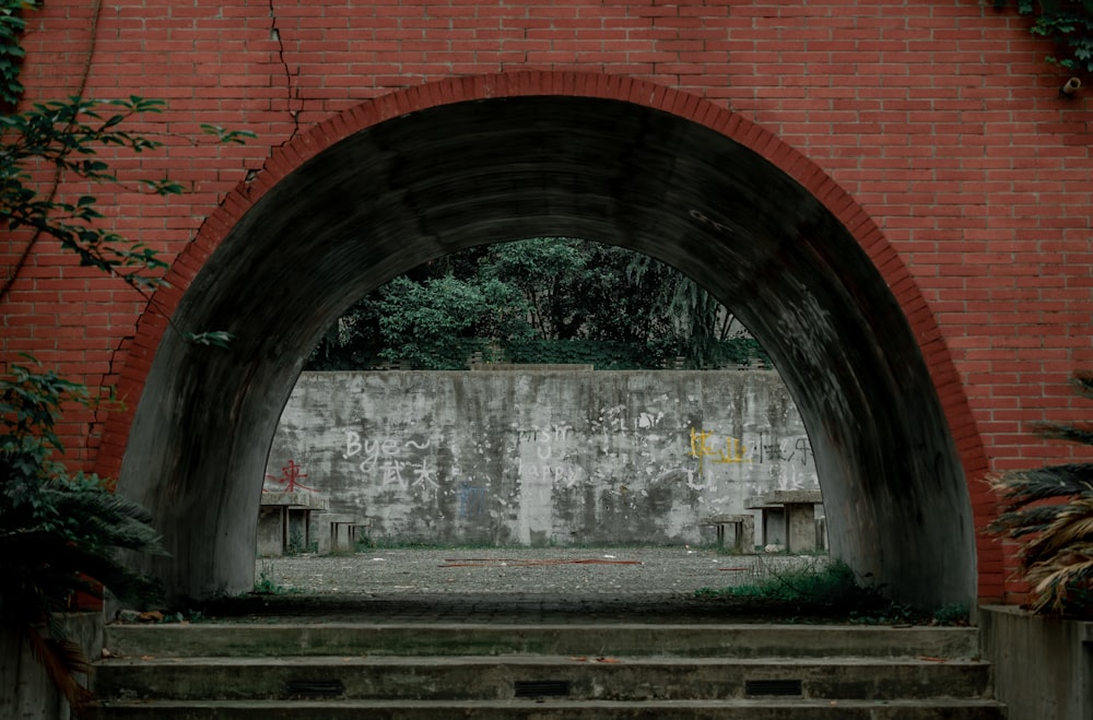 a brick wall with an archway leading into a courtyard