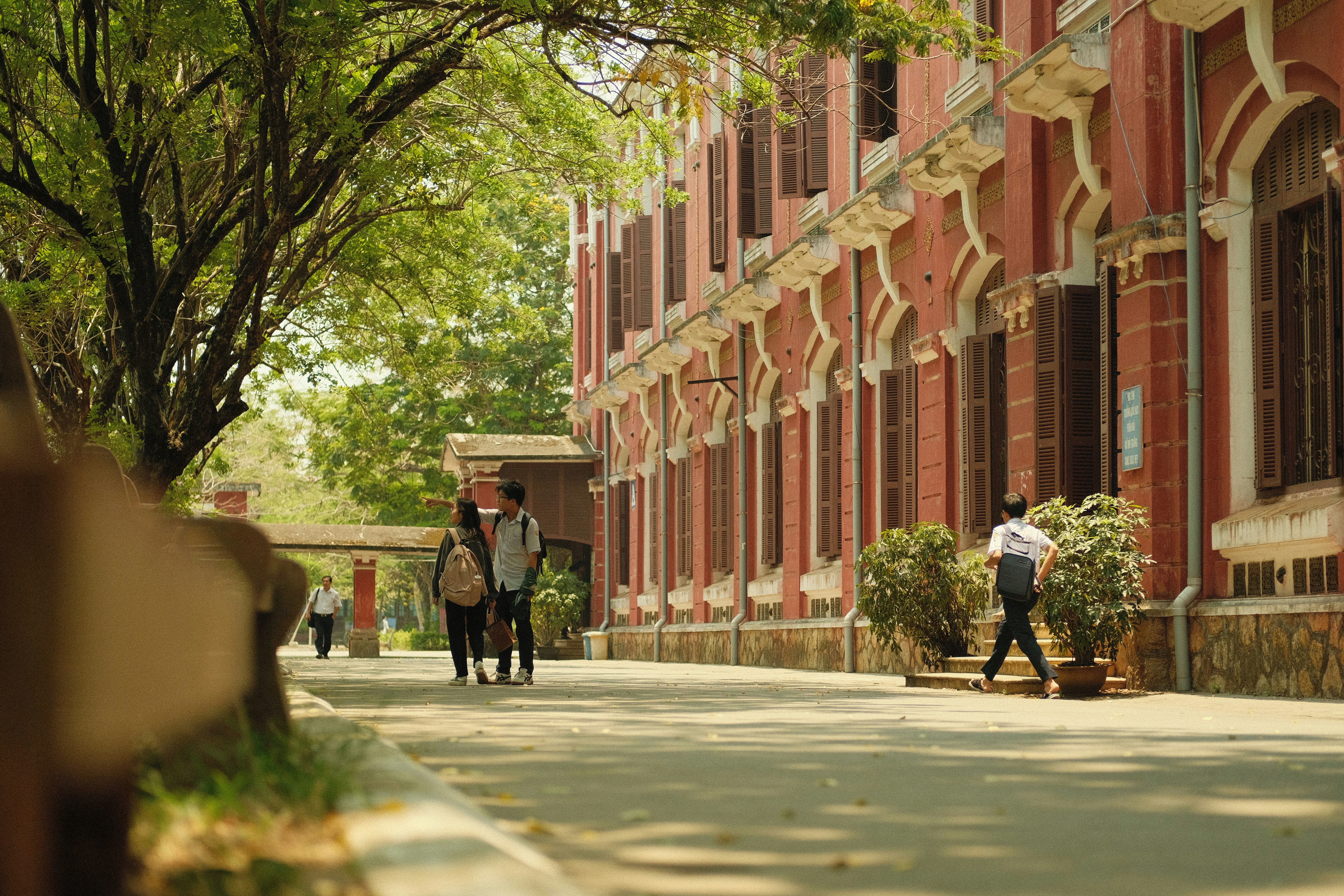 a group of people walking down a street next to tall buildings