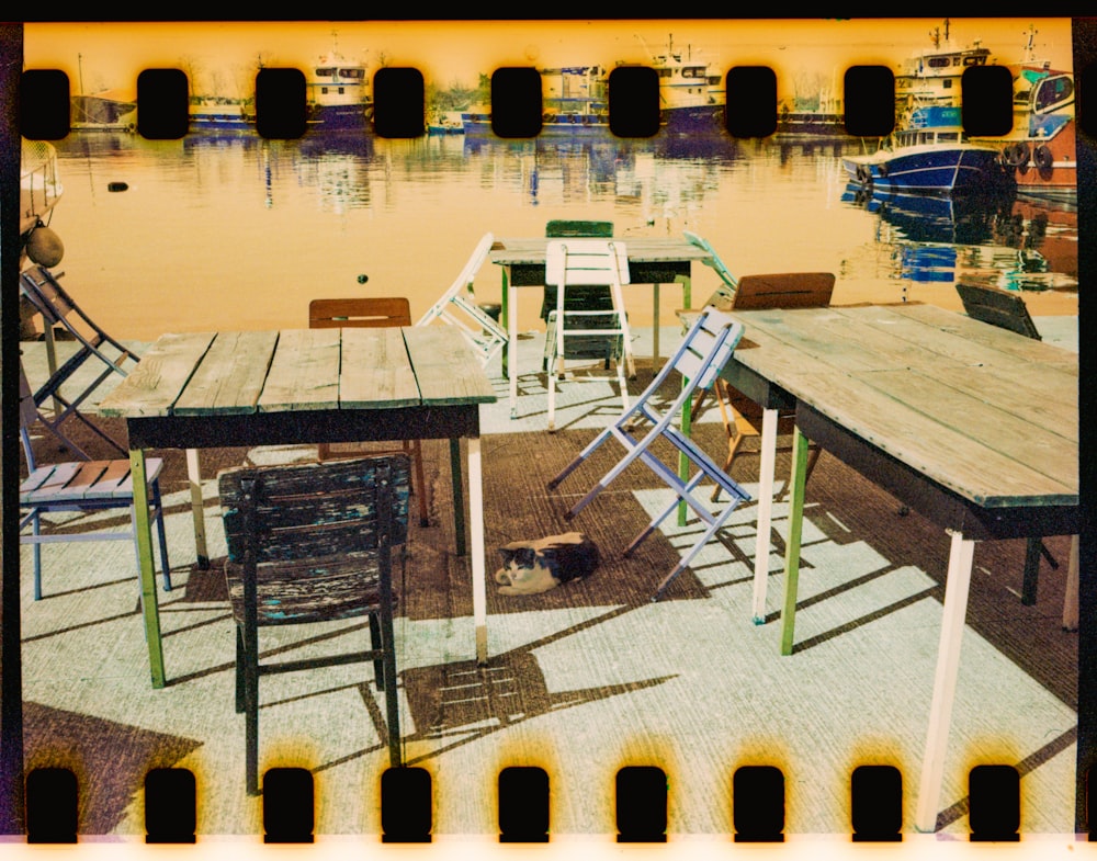 a group of chairs and tables sitting on top of a pier