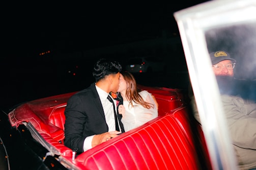 a man and a woman kissing in a red car