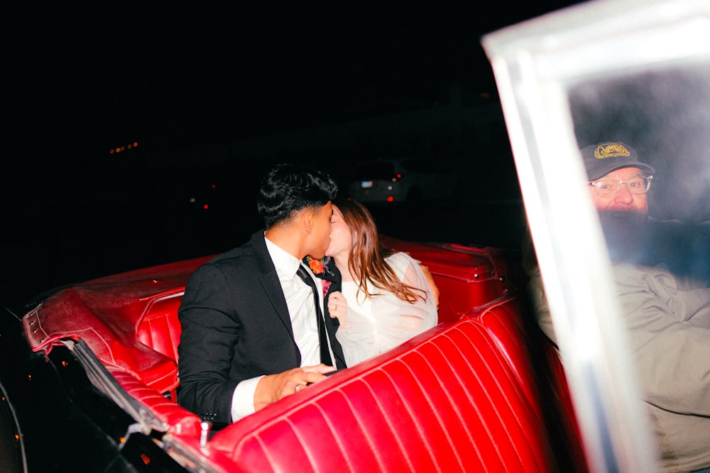 a man and a woman kissing in a red car