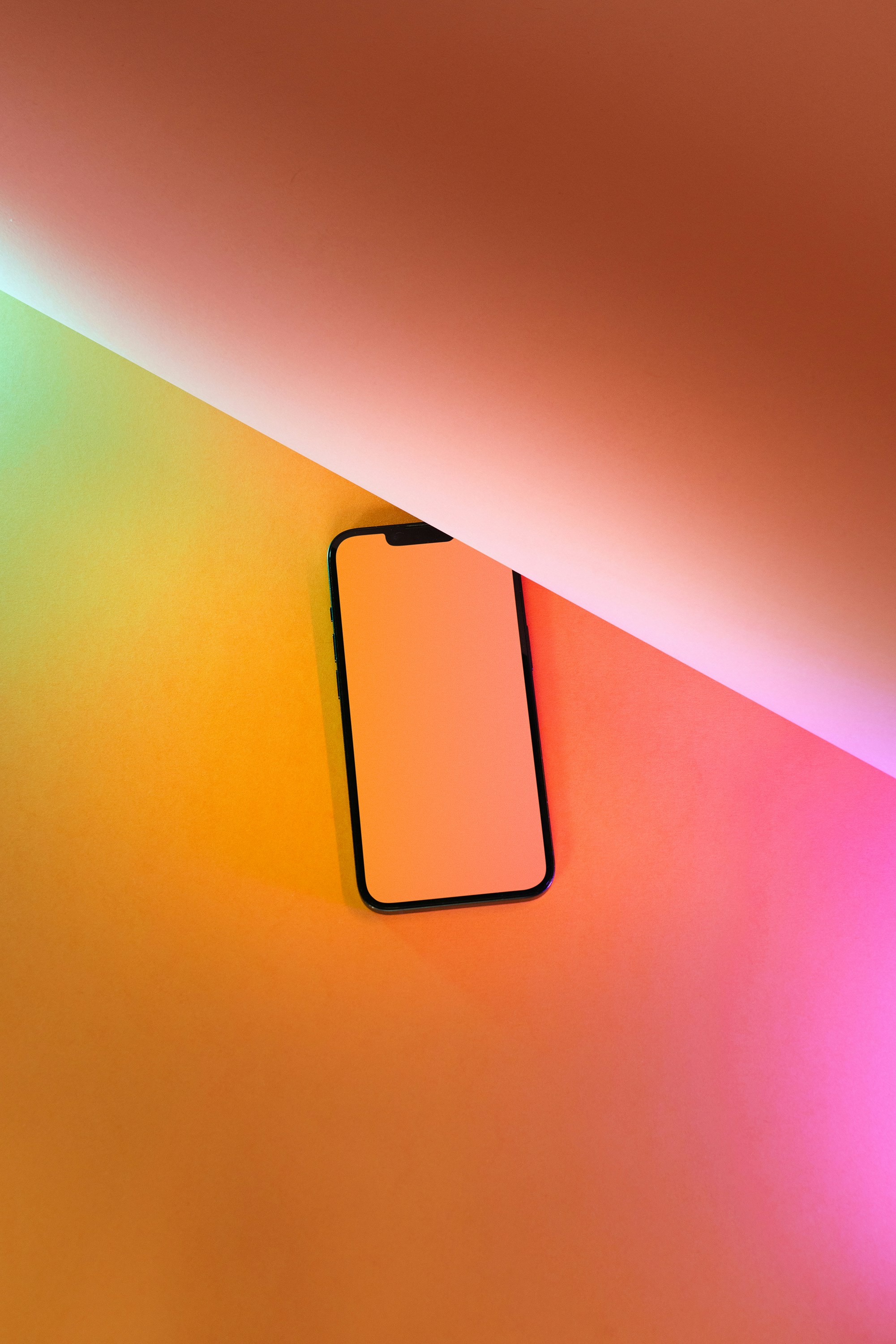 a cell phone sitting on top of a colorful wall