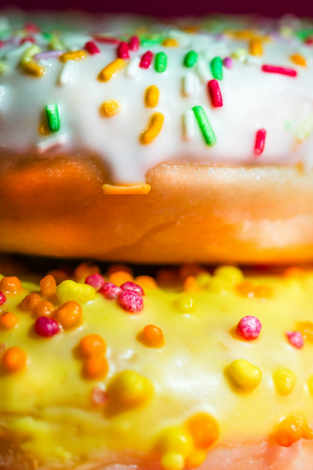 a close up of two donuts with sprinkles