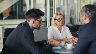 a group of people sitting around a table talking