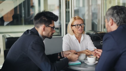 a group of people sitting around a table talking