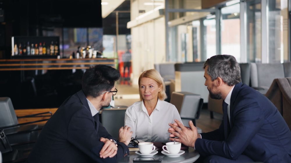 a group of people sitting around a table talking