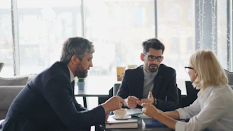 a group of people sitting around a table talking
