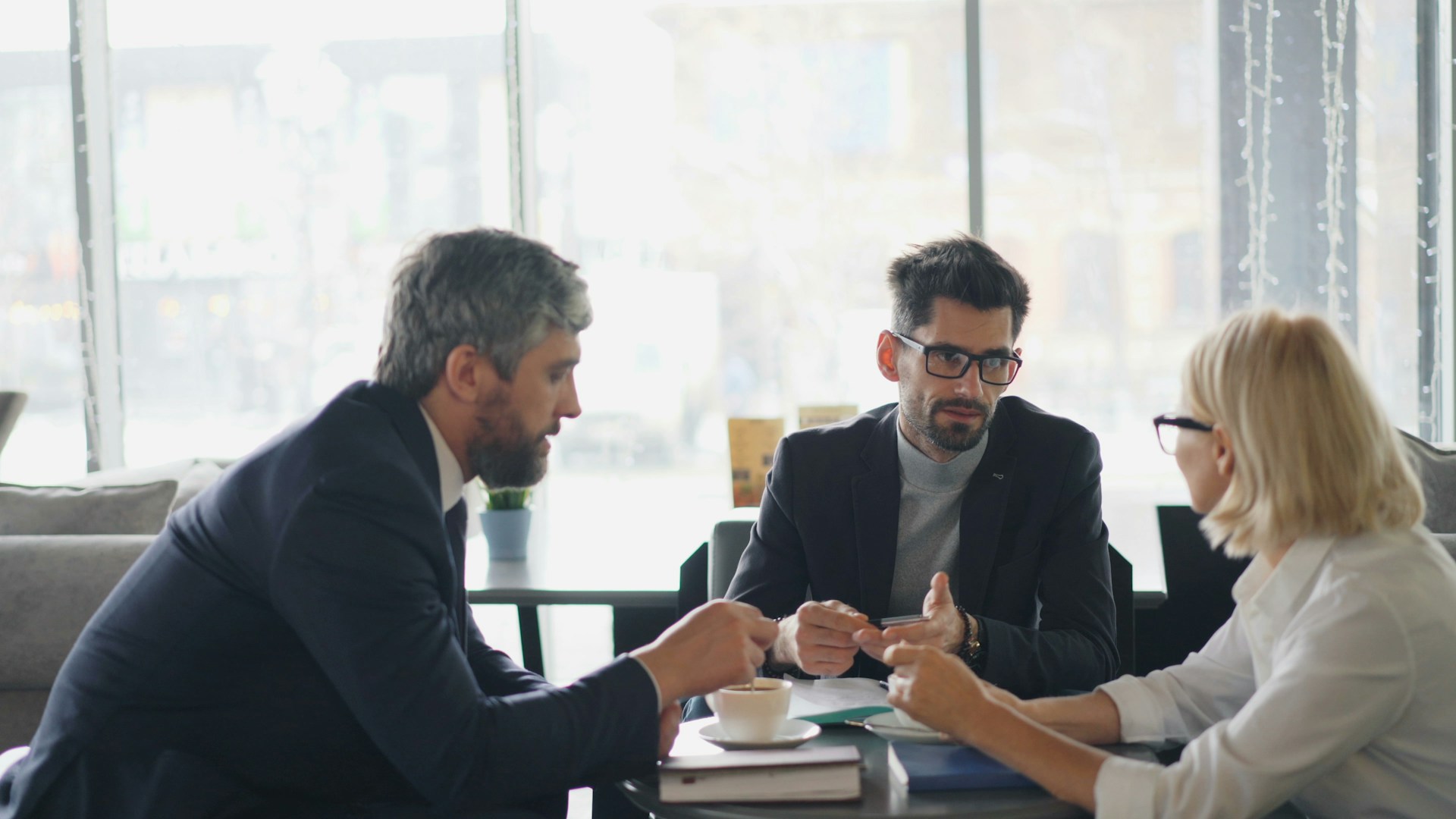 a group of people sitting around a table talking