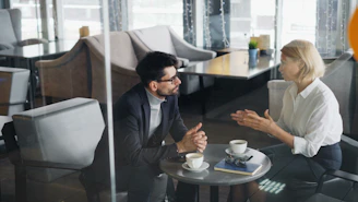 a man and a woman sitting at a table talking