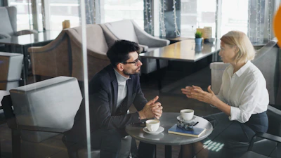 a man and a woman sitting at a table talking