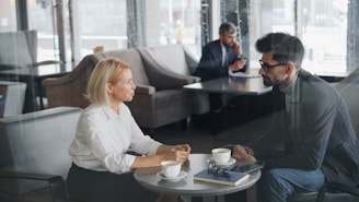 a man and a woman sitting at a table talking