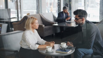 a man and a woman sitting at a table talking