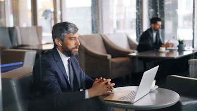 a man sitting at a table using a laptop computer
