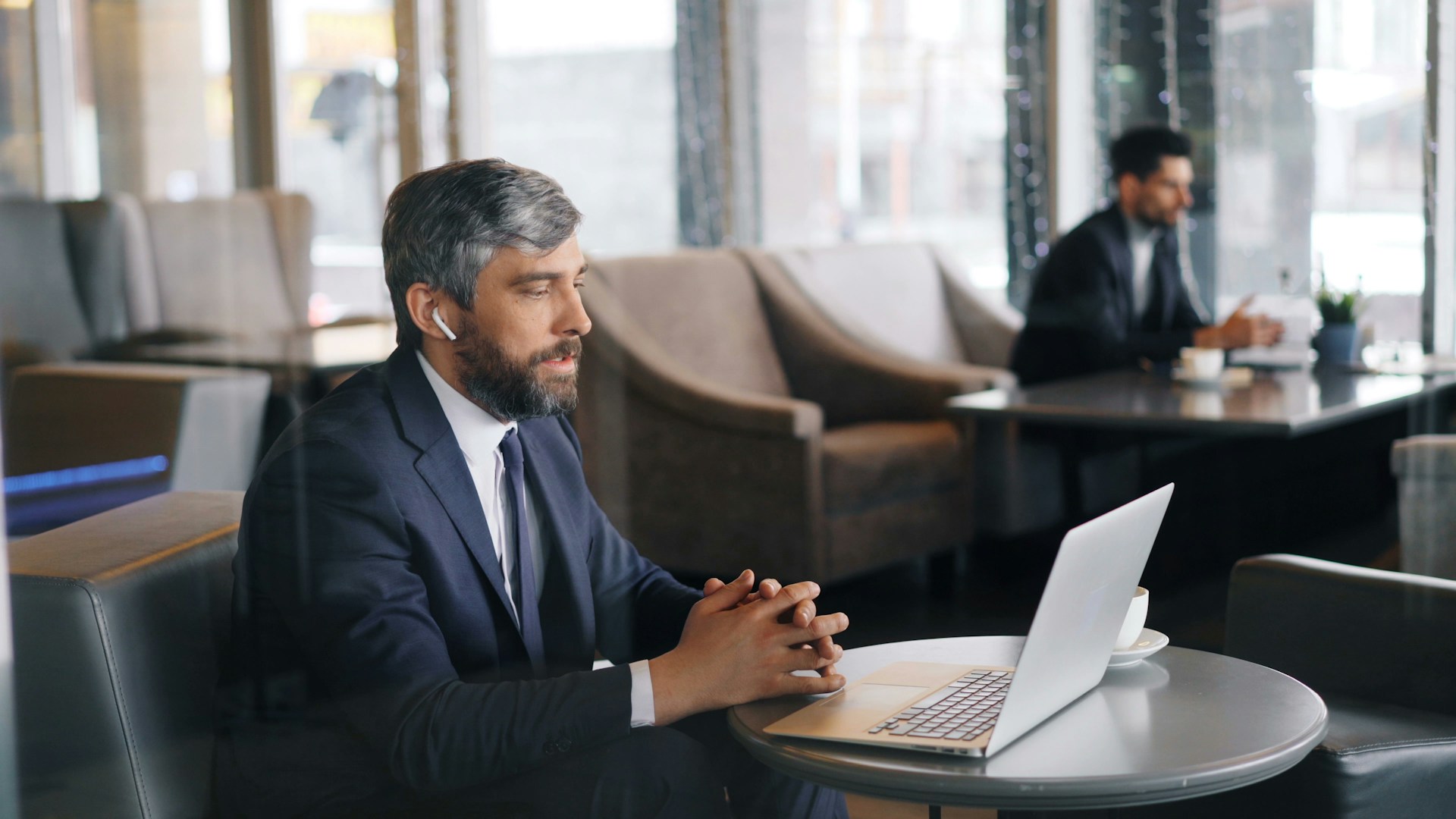 a man sitting at a table using a laptop computer